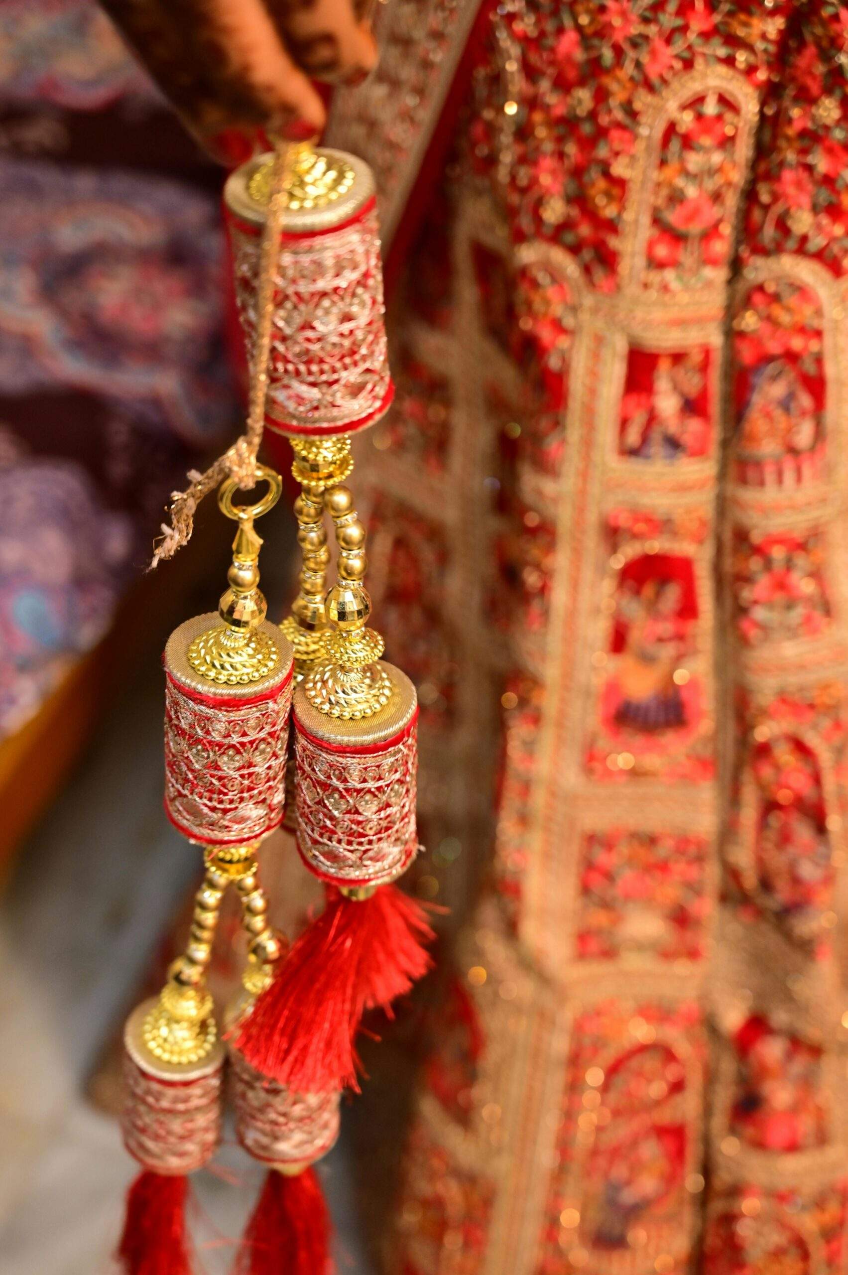 Close-up of traditional Indian bridal kalire ornaments, intricately designed in red and gold.